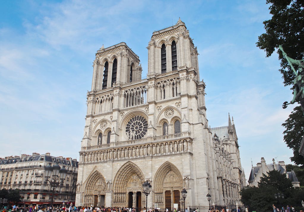 Architectural beauty of Notre Dame Cathedral with crowds in Paris, France.