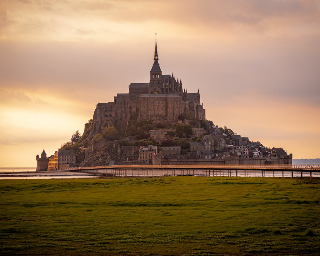 Breathtaking view of Mont-Saint-Michel with stunning sunset hues highlighting historic architecture.