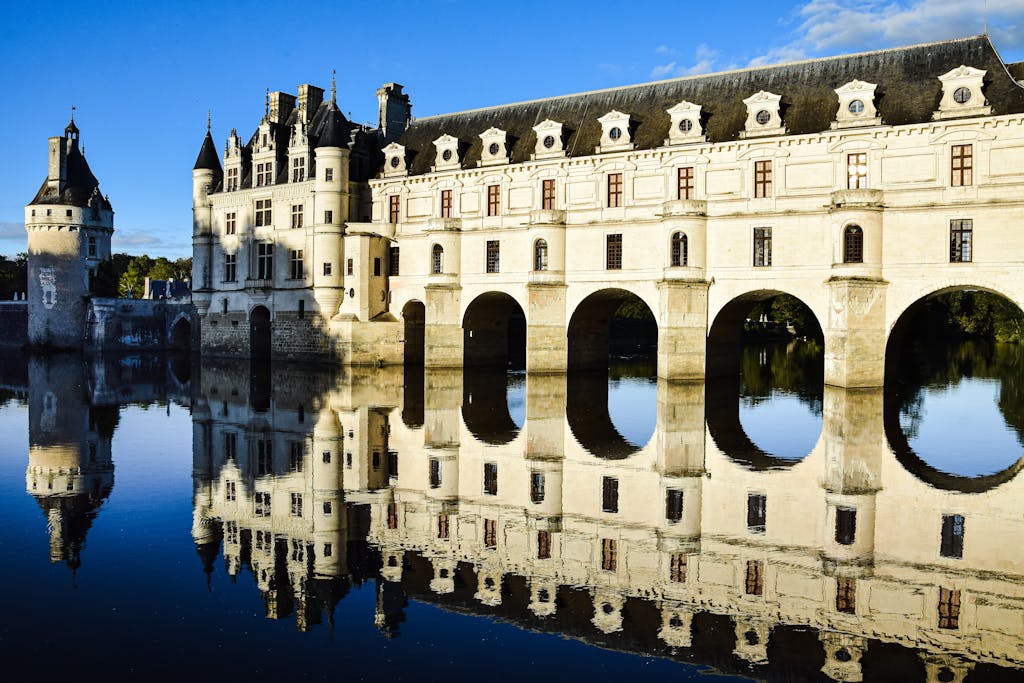 Stunning view of the Château de Chenonceau reflecting on the calm waters of the River Cher in France.