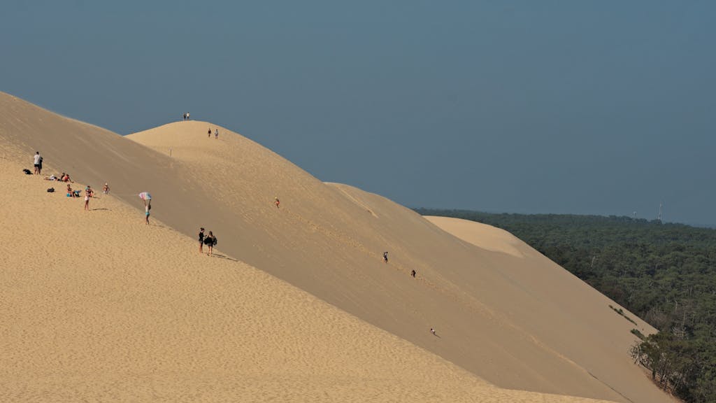 Visitors enjoying the vast sands of the Dune of Pilat, France's famous natural landmark.